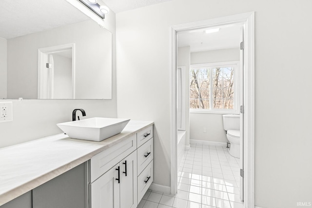 bathroom with tile patterned floors, vanity, toilet, and a textured ceiling