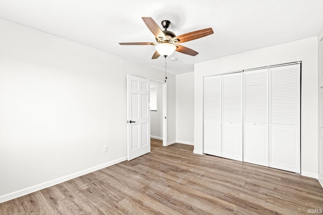 unfurnished bedroom featuring a closet, light hardwood / wood-style flooring, and ceiling fan