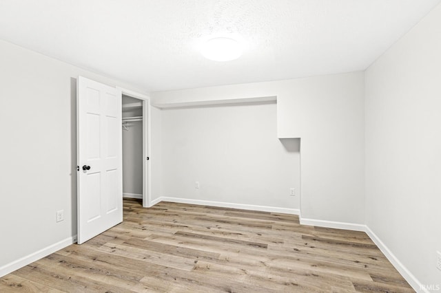 unfurnished bedroom featuring light wood-type flooring and a closet