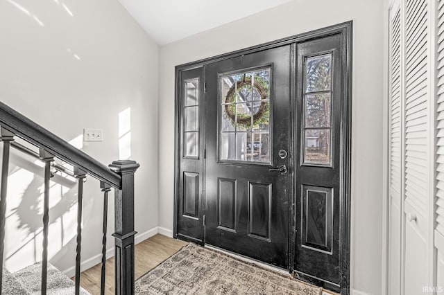 entrance foyer with hardwood / wood-style flooring and vaulted ceiling