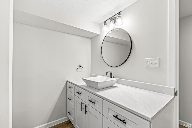 bathroom featuring hardwood / wood-style floors, vanity, and a textured ceiling