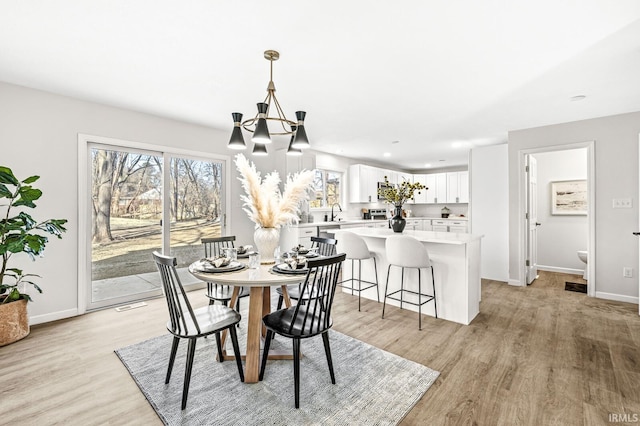 dining area featuring an inviting chandelier and light hardwood / wood-style flooring