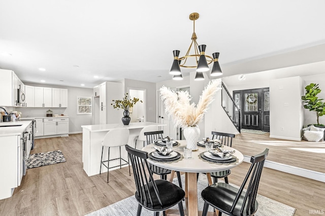 dining room featuring an inviting chandelier, light hardwood / wood-style flooring, and sink