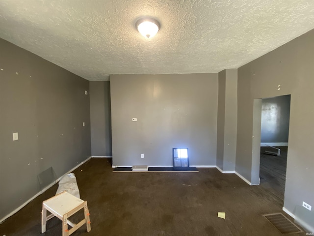 carpeted empty room with a textured ceiling