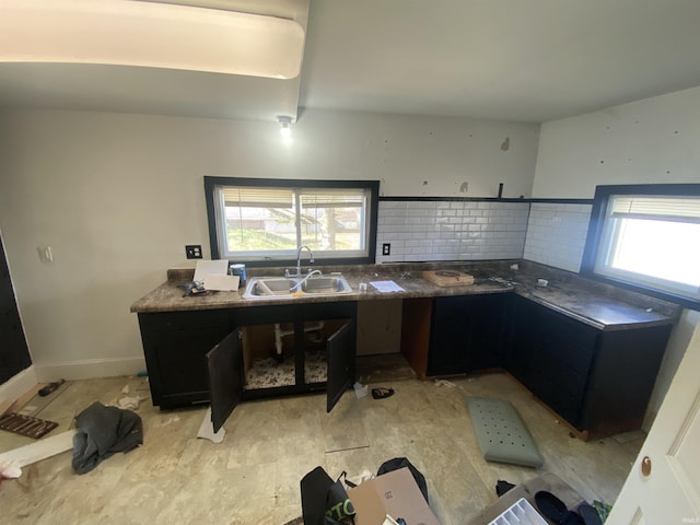 kitchen with backsplash, a wealth of natural light, sink, and light hardwood / wood-style flooring