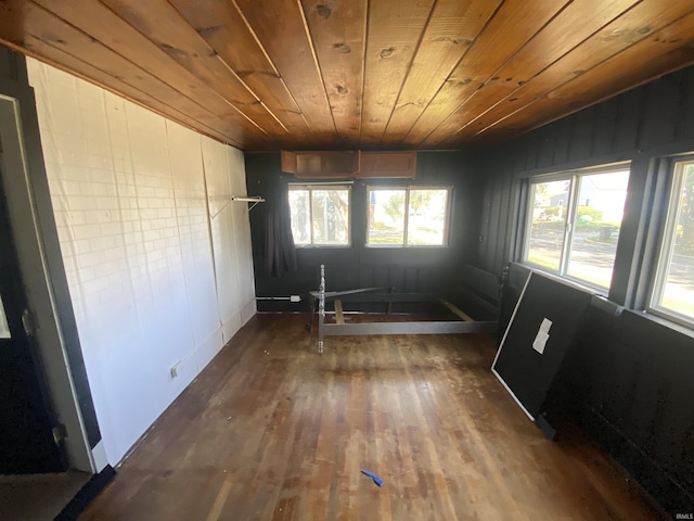 empty room with dark hardwood / wood-style flooring and wooden ceiling