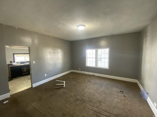 carpeted spare room featuring plenty of natural light