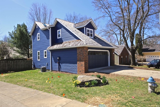 view of front of house with central air condition unit, a front yard, and a garage