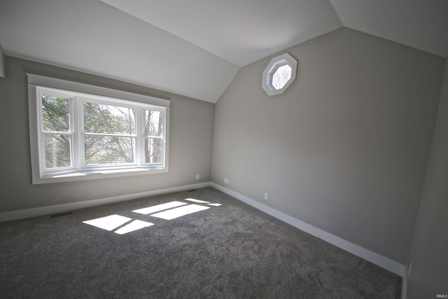 additional living space with dark colored carpet and lofted ceiling