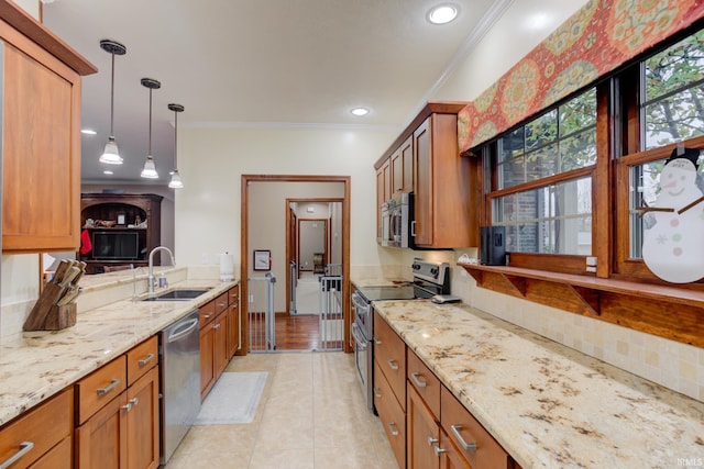 kitchen with pendant lighting, ornamental molding, sink, and appliances with stainless steel finishes