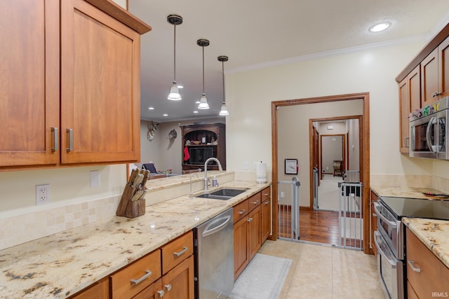 kitchen with sink, pendant lighting, light wood-type flooring, appliances with stainless steel finishes, and ornamental molding