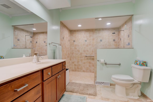 bathroom featuring crown molding, toilet, vanity, and tiled shower