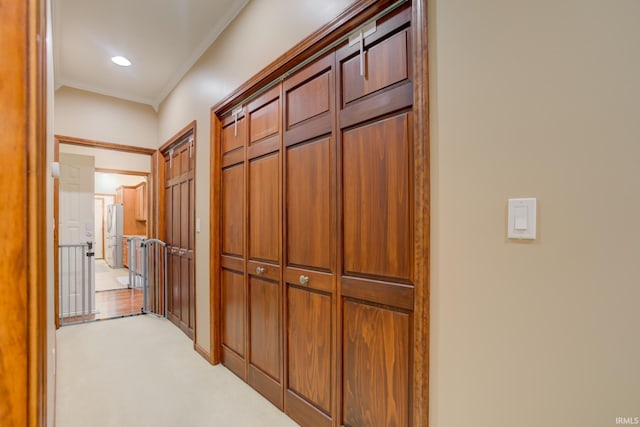 corridor featuring crown molding and light carpet