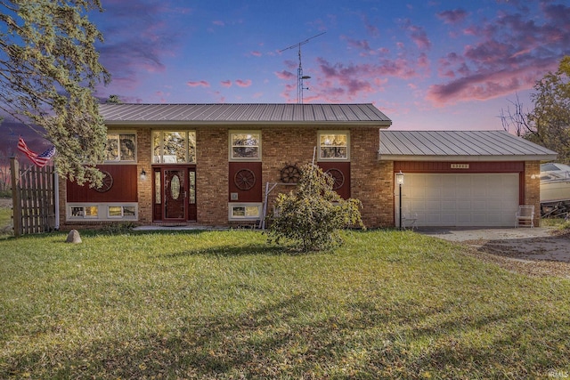 view of front facade featuring a garage and a lawn