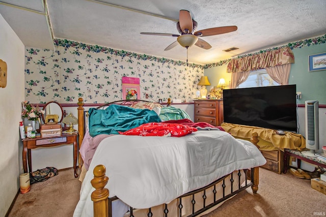 carpeted bedroom with ceiling fan and a textured ceiling