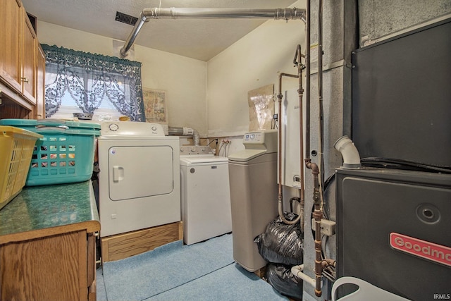 clothes washing area featuring cabinets, separate washer and dryer, a textured ceiling, and heating unit