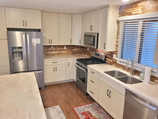 kitchen featuring backsplash, sink, stainless steel appliances, and hardwood / wood-style flooring