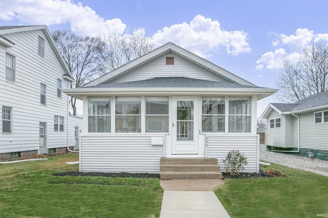 bungalow with a sunroom and a front yard