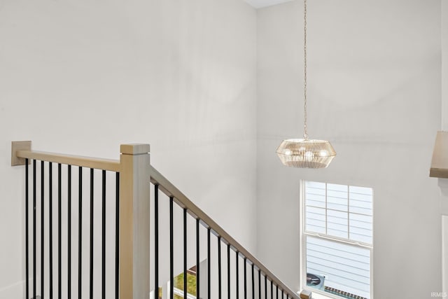 stairs with a chandelier