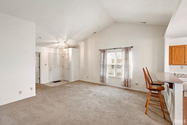 interior space with lofted ceiling and light carpet