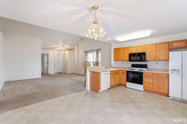 kitchen with kitchen peninsula, white appliances, vaulted ceiling, sink, and pendant lighting