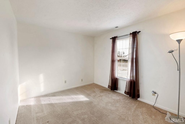 carpeted empty room with a textured ceiling