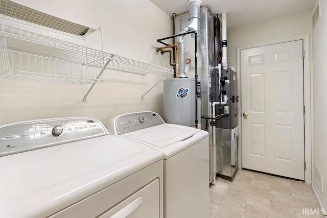 laundry area with water heater and independent washer and dryer