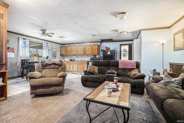 living room featuring light tile patterned floors, ceiling fan, and crown molding