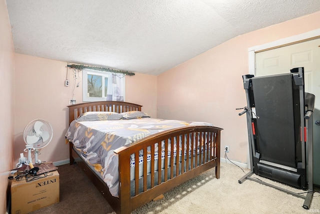 bedroom featuring light colored carpet, lofted ceiling, and a textured ceiling