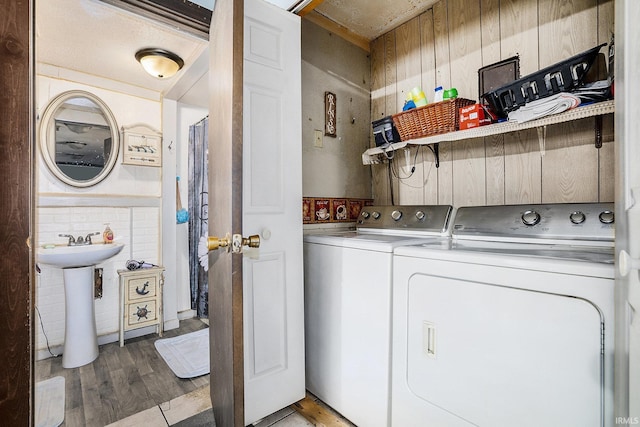 laundry room with washing machine and dryer, hardwood / wood-style floors, and sink