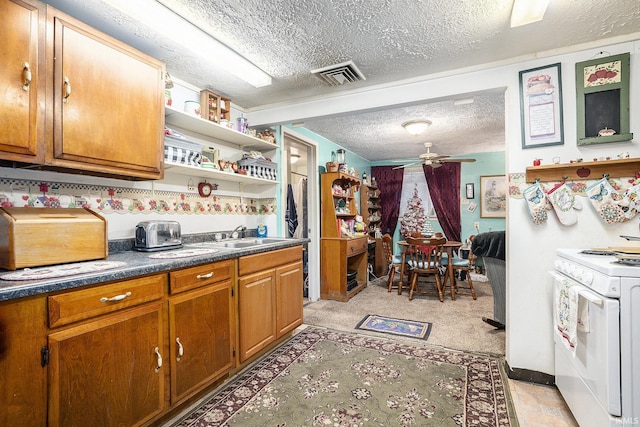 kitchen with ceiling fan, sink, white electric stove, a textured ceiling, and light carpet