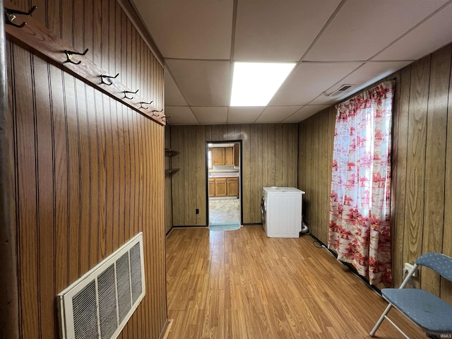 washroom featuring light hardwood / wood-style flooring and wooden walls