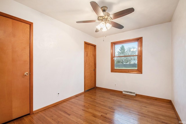 empty room with ceiling fan and hardwood / wood-style flooring