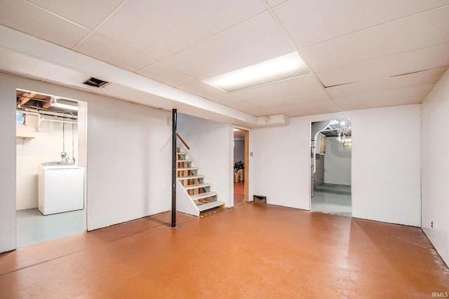 basement featuring a paneled ceiling, washer / clothes dryer, and fridge