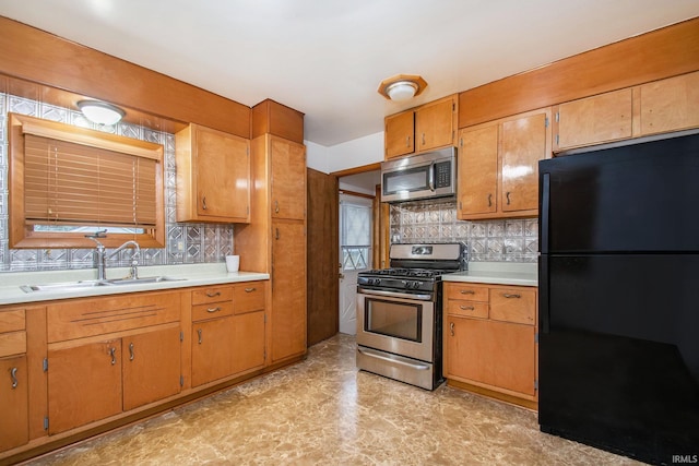 kitchen with tasteful backsplash, sink, and appliances with stainless steel finishes