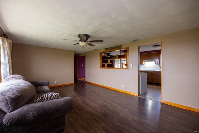 living room featuring ceiling fan and dark wood-type flooring