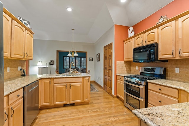 kitchen with lofted ceiling, light hardwood / wood-style flooring, decorative light fixtures, kitchen peninsula, and stainless steel appliances