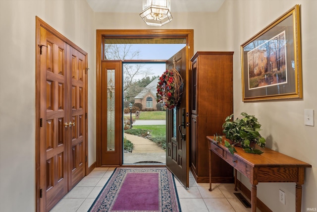 tiled foyer with a chandelier