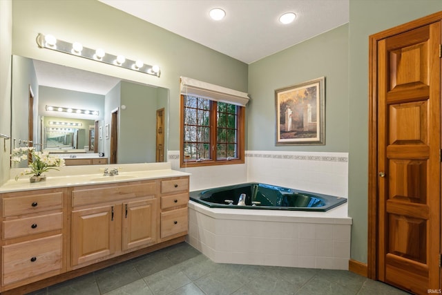 bathroom with tile patterned floors, tiled bath, and vanity