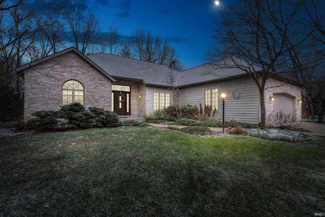 ranch-style home featuring a garage and a front lawn