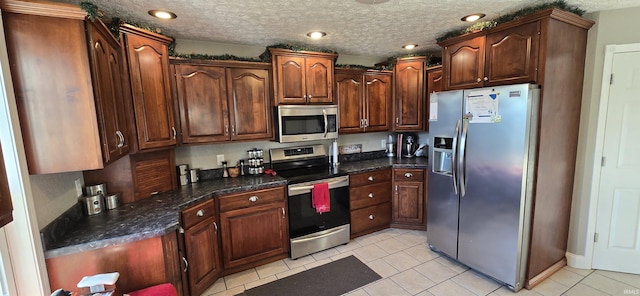 kitchen with appliances with stainless steel finishes and a textured ceiling