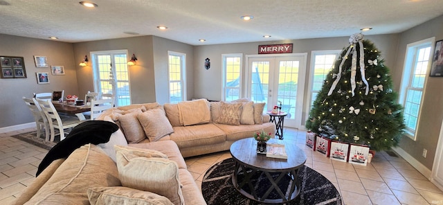 tiled living room featuring french doors and a textured ceiling