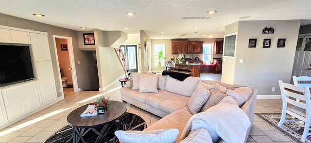 tiled living room featuring a textured ceiling