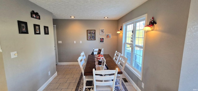 tiled dining space featuring a textured ceiling