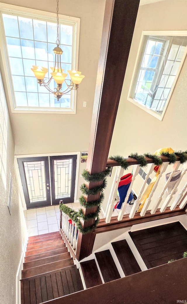 foyer with plenty of natural light, wood-type flooring, and a notable chandelier