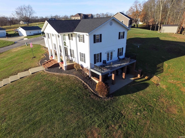 rear view of property featuring a yard and a wooden deck