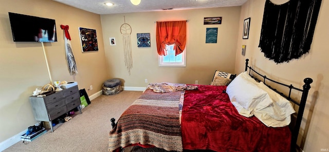 bedroom with light colored carpet and a textured ceiling