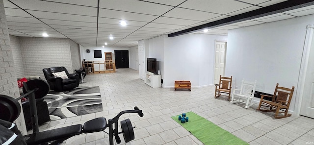 interior space with a drop ceiling and light tile patterned floors