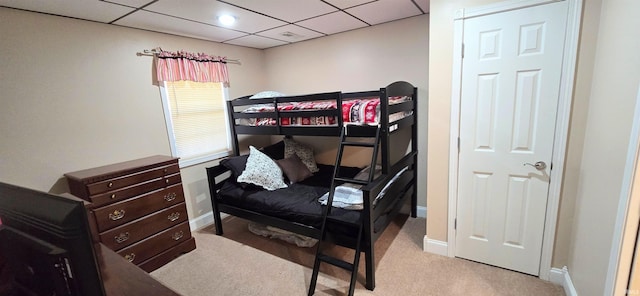 bedroom featuring a paneled ceiling and light colored carpet