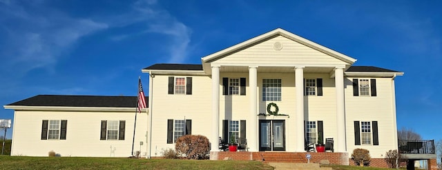 greek revival house featuring a front yard